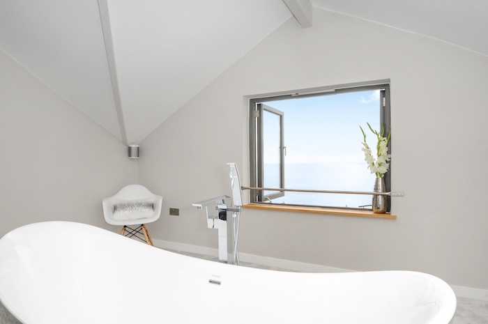 salle de bain moderne, pièce sous pente, petite chaise blanche avec pieds en bois, fleurs blanches