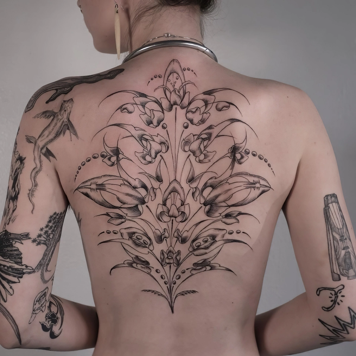 dessin corps femme tatouage fleur dos motifs feuilles graines petales