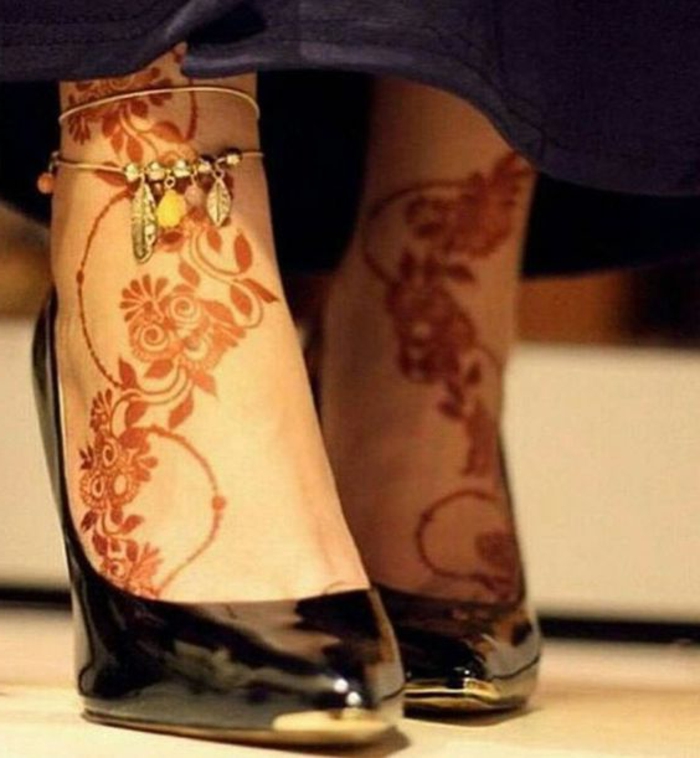 dessin de henné, pieds décorés de henné et chaussures noires laquées