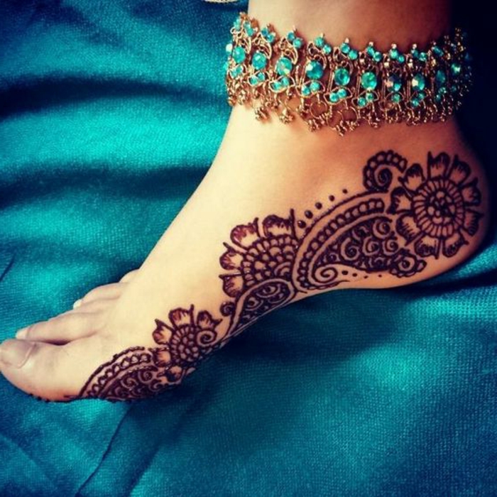 dessin henné, motifs végétaux dessinés sur le pied, bracelet avec pierres bleues