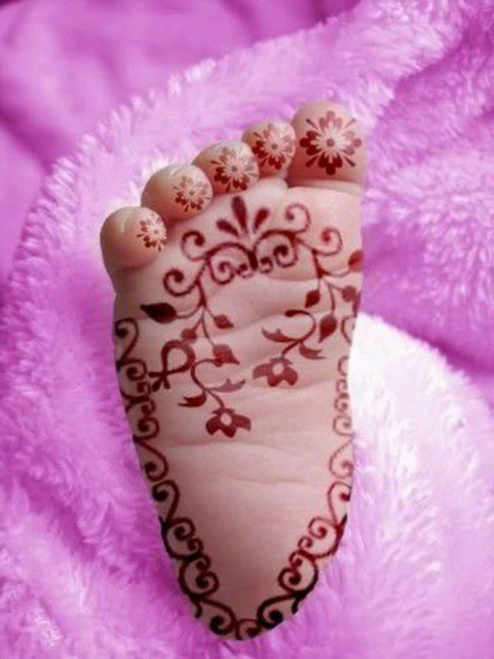 dessin henné, petit pied de bébé avec tatouage à la plante, motifs floraux symétriques aux orteils