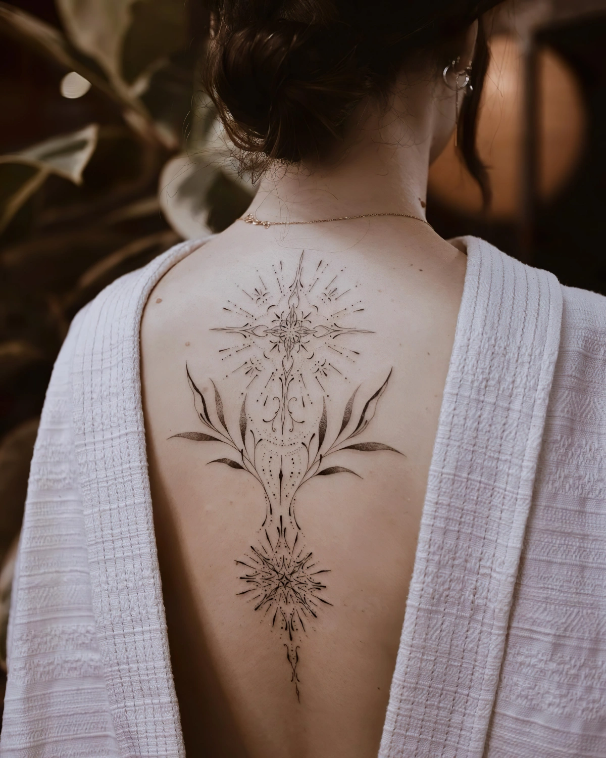 dessin motifs symbolisme tatouage haut du dos femme cheveux chignon
