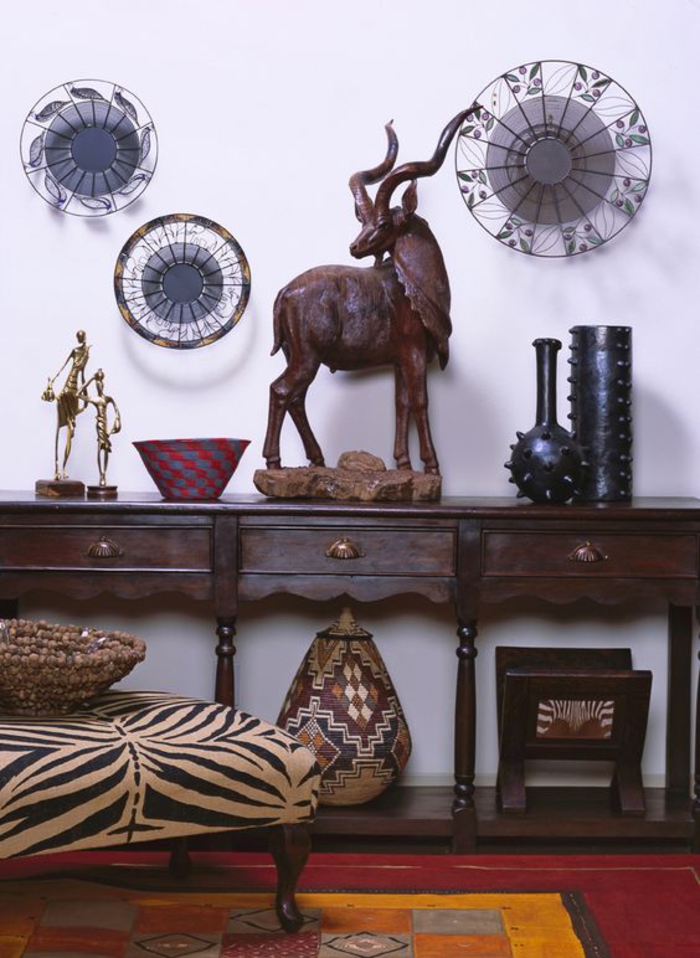 des accents déco africains naturels, objets d'art tribal, mobilier vintage en bois foncé, salon ethnique chic africain