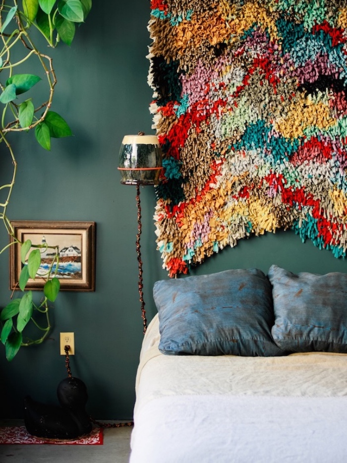 tete de lit a faire soi meme en tapis multicolore, mur couleur ver émeraude, coussins bleus et linge de lit blanc, plante verte