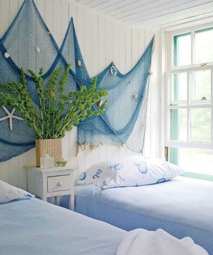 suggestion originale comment faire une tete de lit en filet de pèche bleu, decoration coquillages, étoile de mer, linge de lit blanc et bleu, lambris blanc