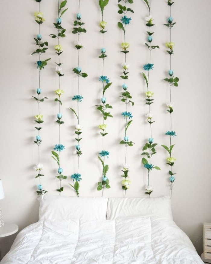fabriquer une tete de lit en guirlande de fleurs suspendues, deco florale jaune, blanche et bleue, linge de lit blanc