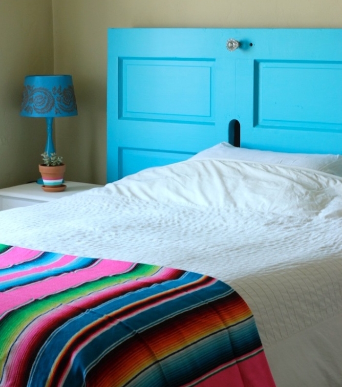 idée comment faire une tete de lit en vieille porte, repeinte en bleu, linge de lit blanc et couverture multicolore à rayures