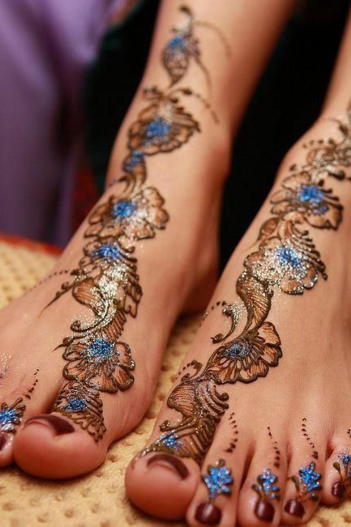 henne pied, dessins en bleu et marron aux éléments lumineux, jolie décoration florale
