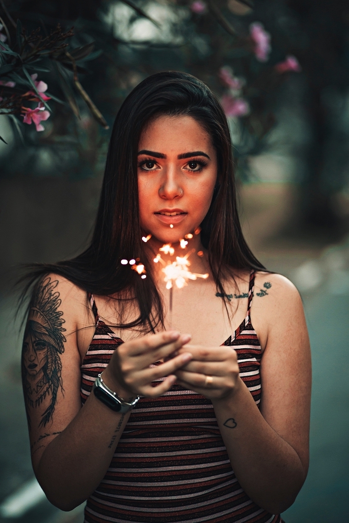 tatouage femme amérindienne à coiffe de plumes sur le bras accompagné de quelques tattoos phrase sur l'avant-bras et la clavicule, modele tatouage inspiré de la culture amérindienne