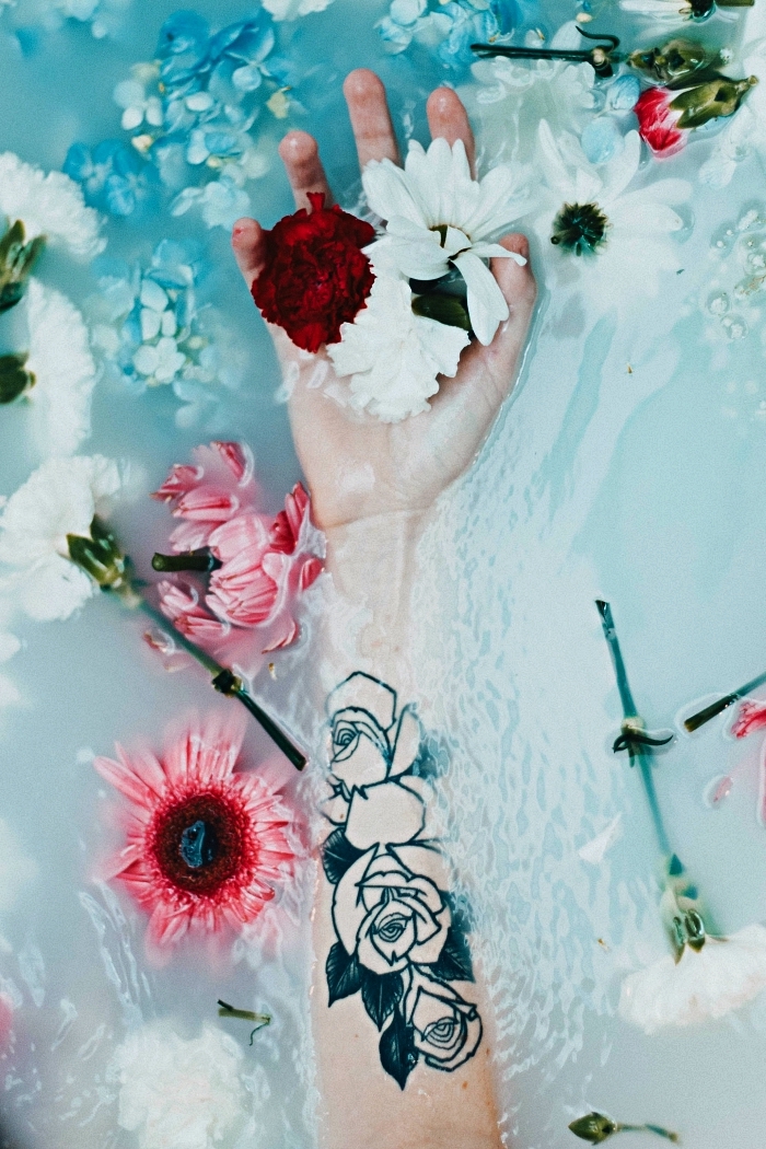 tatouage avant bras femme composé de trois roses à dessin graphique, idée de tatouage féminine à l'intérieur de l'avant-bras 
