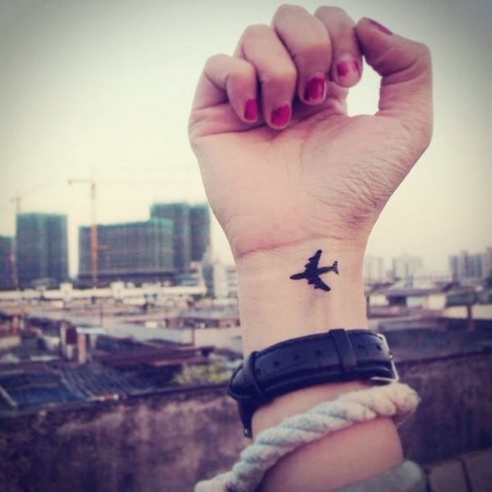 petit tatouage poignet, un avion encre noire, idée de tatouage voyage femme