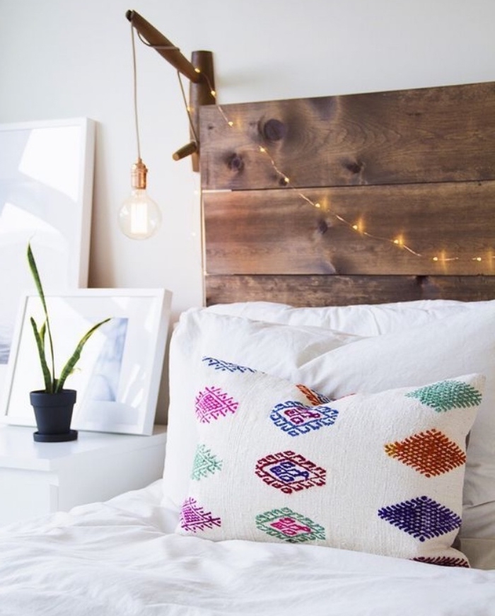 bricolage tete de lit en palette, planches de bois et guirlande lumineuse pour une ambiance romantique, linge de lit blanc et coussin motif azteque
