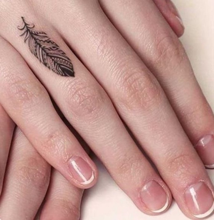 tatouage petit sur le doigt, phalange, plume, motifs tribal amérindiens, idée de tatouage femme créative