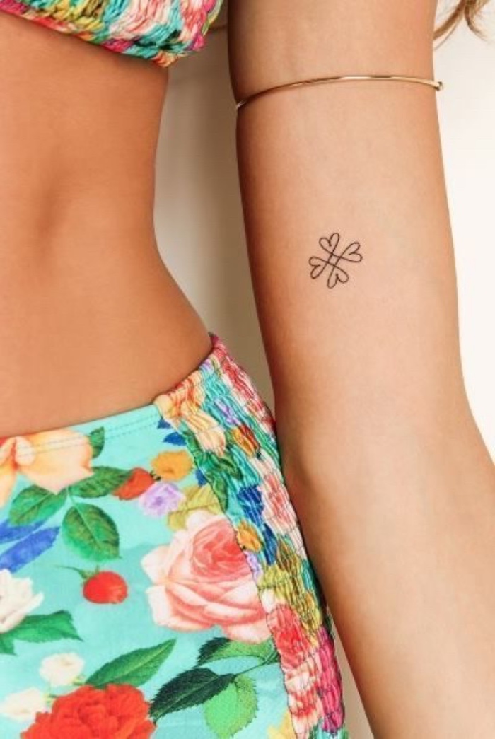 petit tatouage femme, avant bras, une fleur constituée de petits coeurs, tenue été motifs tropicaux