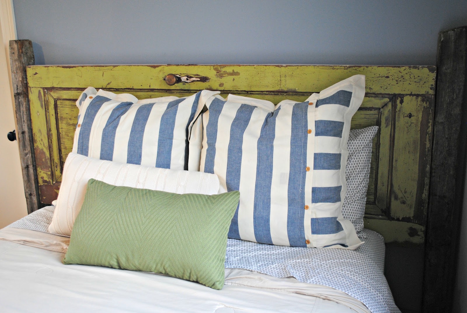 idée pour fabriquer une tete de lit en porte bois brut usée, linge de lit blanc, vert et bleu, mur couleur bleue