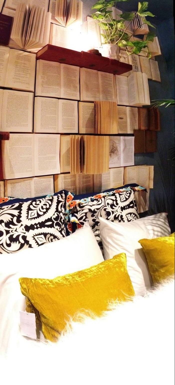 encore une idée pour fabriquer une tete de lit en livres ouverts, coussins motif azteque et coussins jaunes et blancs, couverture de lit blanche, lampe sur une étagère