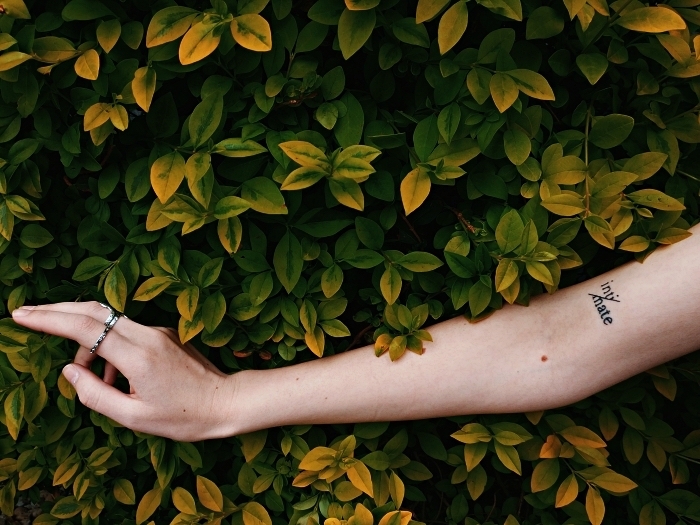 tatouage simple à l'intérieur du bras représentant un mot découpé en deux par un trait, tatouage mot inspirant