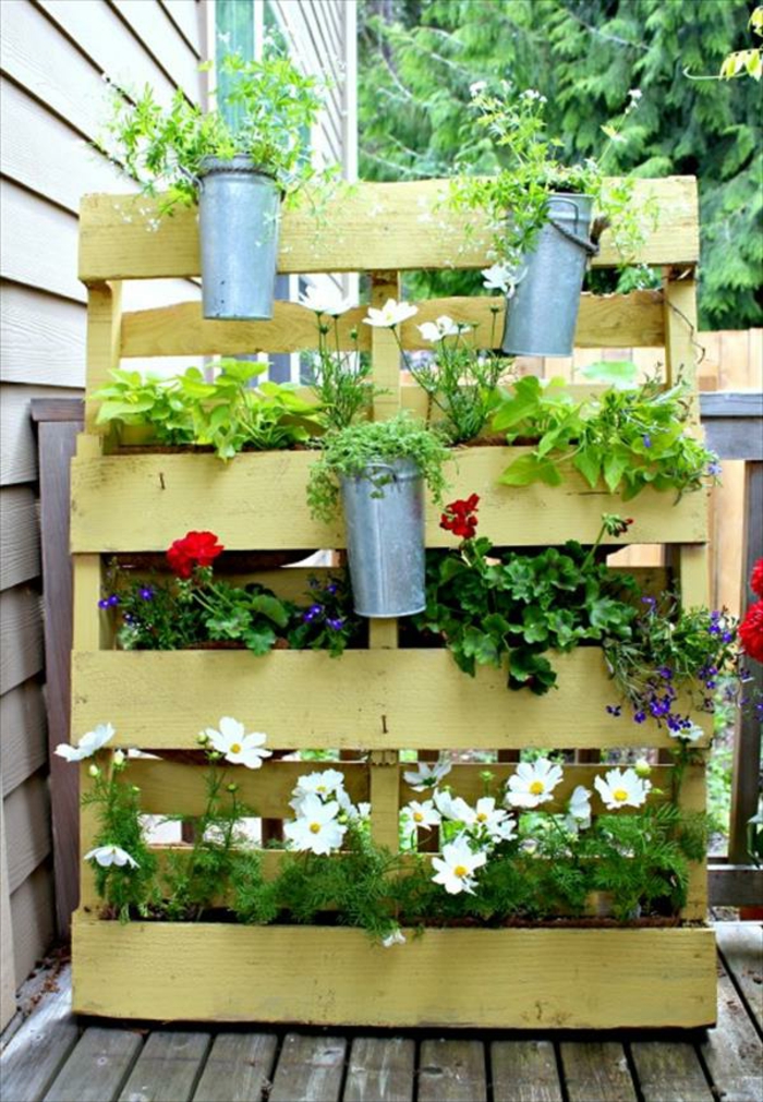 jardiniere en palette, décorée en jaune, rangement pour pots de fleurs, terrasse en bois de teck, decoration exterieure