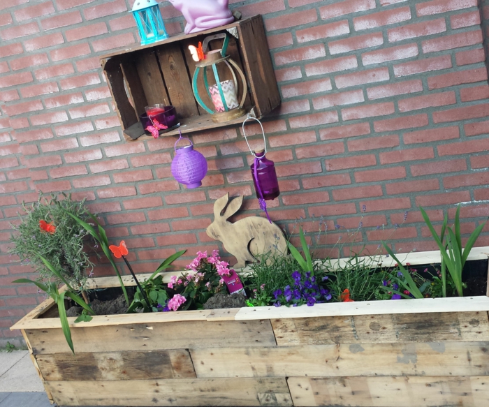 jardiniere en palette avec des fleurs plantées dedans, decoration exterieure printaniere, une etagere en cagette