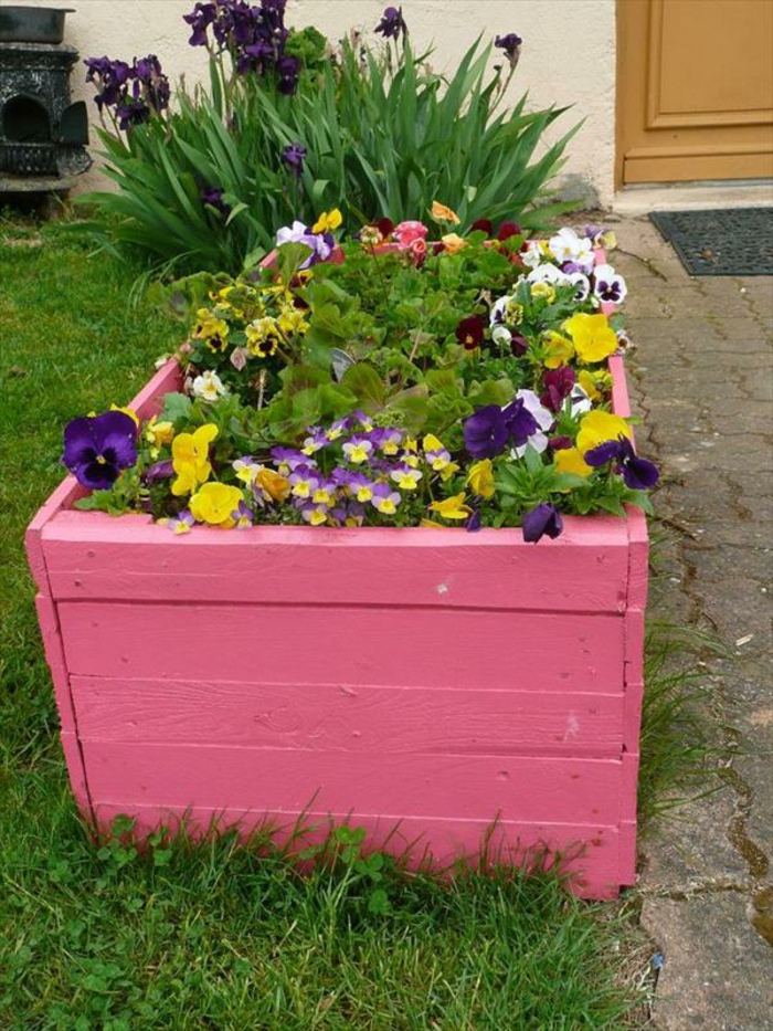 jardiniere palette de bois, composée de planches repeintes en rose, idée décoration extérieure, plantes de couleurs diverses