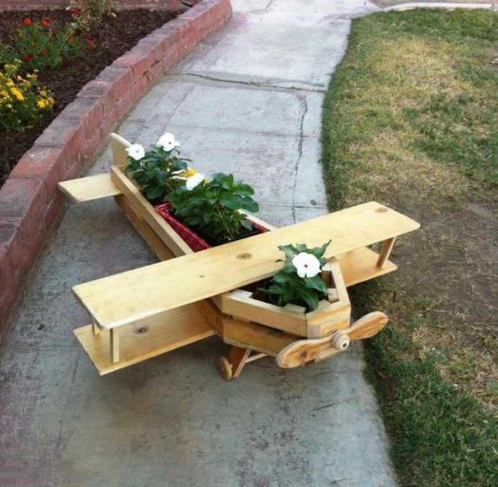 jardiniere palette design intéressant, un avion en planches de bois poli, des fleurs plantées, deco jardin exterieur