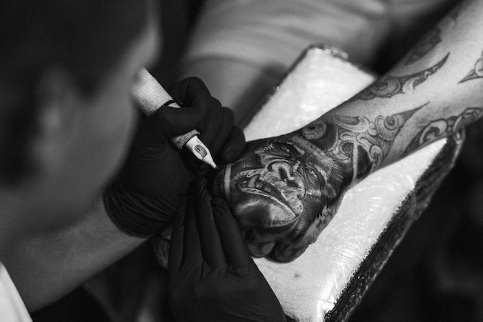 tatouage homme, visite salon de tatouage, design animal, singe, paire de gants noirs, tatouage bras homme