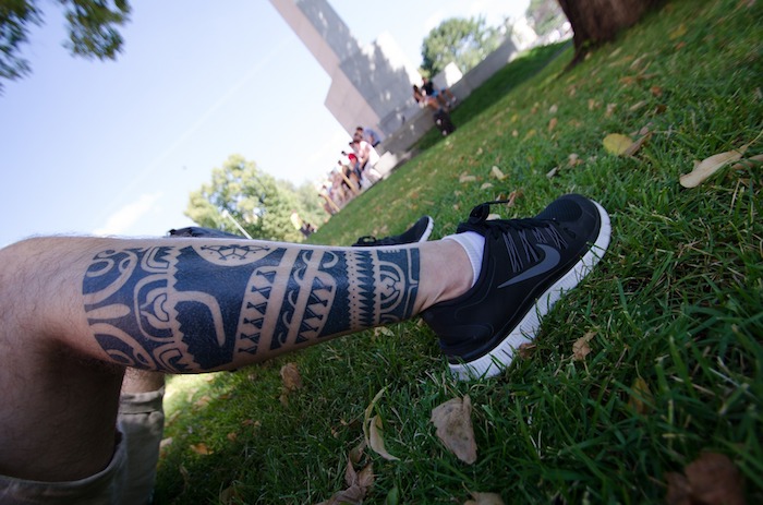 tatouage homme, gazon vert, après midi dans la nature, tatouage polynésien, tattoo sur les jambes, shorts homme beige