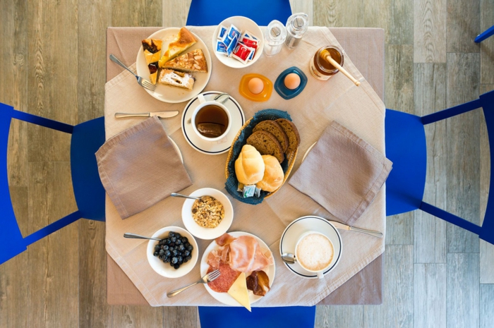 menu équilibré, chaises bleus, parquet en bois, table à manger, oeufs, café art, serviette beige