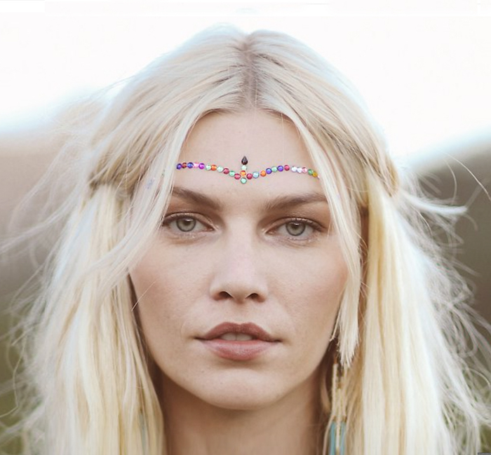 déguisement hippie, femme aux yeux verts, cheveux blonds, maquillage front en cristaux multicolore, femme hippie