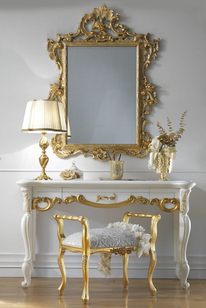 meuble baroc avec tabouret avec des accoudoirs dorés et une coiffeuse en blanc et ornements dorés 