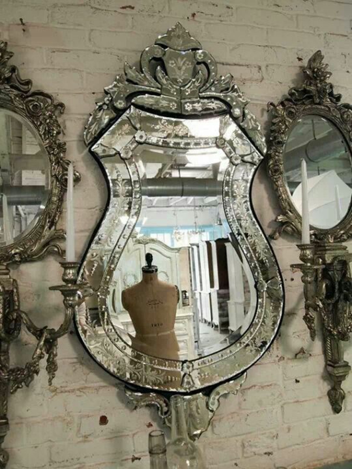 meuble style baroque miroirs étincelants sur un mur de briques blanches 
