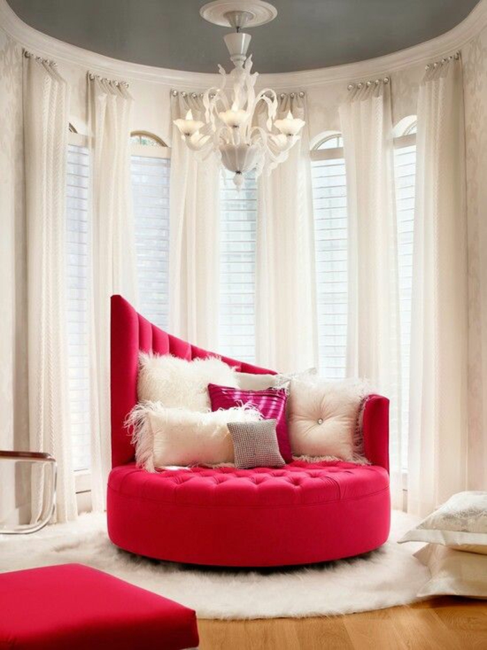 meuble style baroque canapé rond en rouge matelassé avec lustre blanc et des rideaux transparents blancs