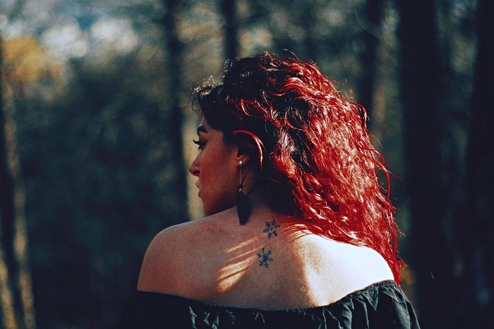 tatouage simple et minimaliste de deux flocons de neige stylisés sur le dos, tatouage dos femme à design discret