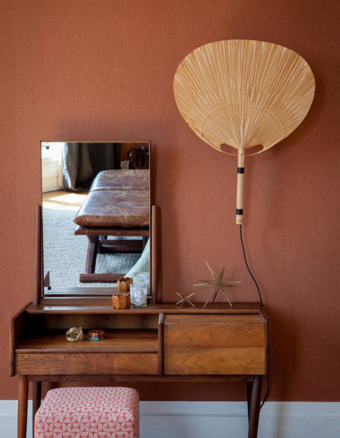 peinture couleur sienne associée à une coiffeuse en bois vintage, un modèle de lampe baladeuse originale en forme d'éventail