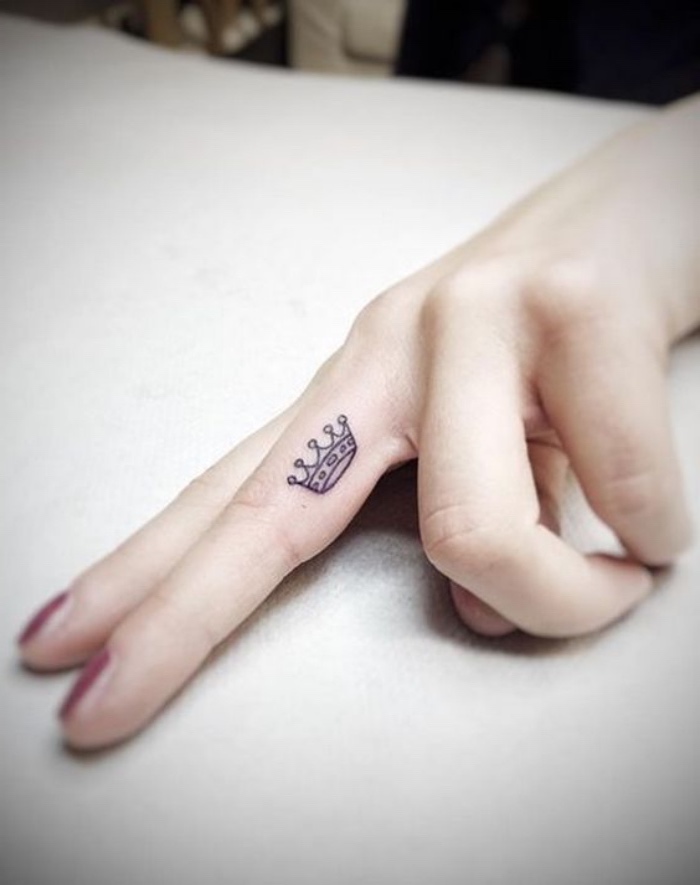 modèle de petit tatouage femme, doigt, phalange, couronne contours noirs, ornements