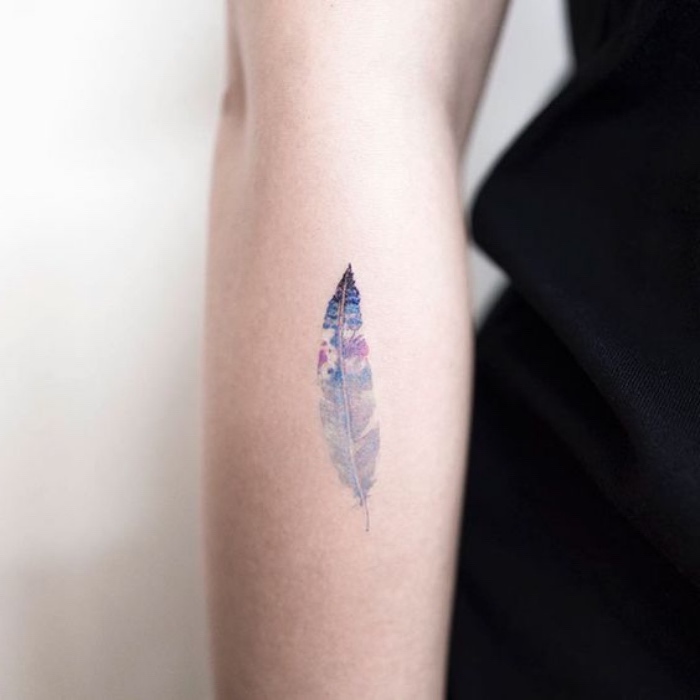 idée de petit tatouage à se faire tatouer, plume coloré, bras femme, dessin coloré
