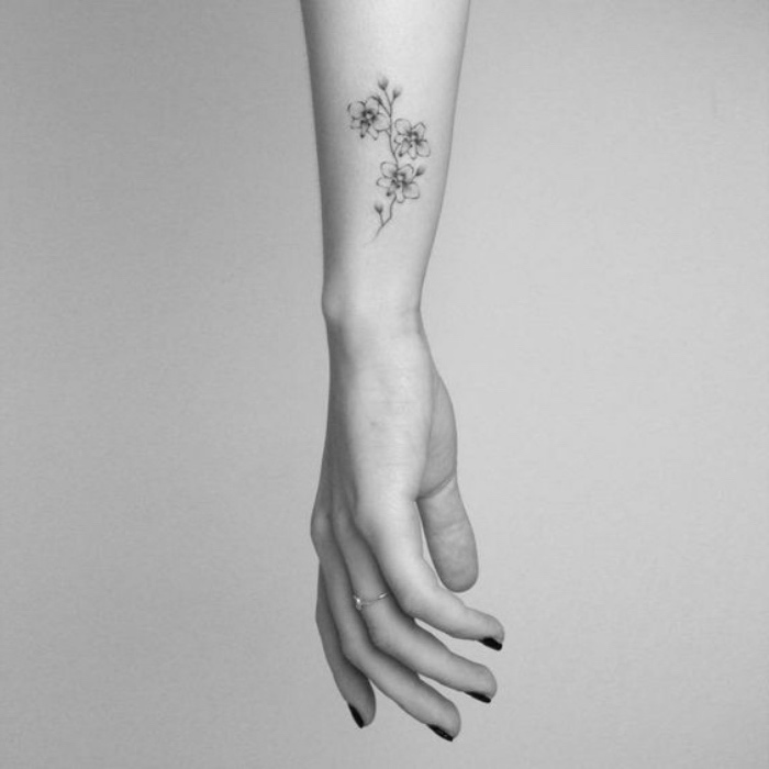 petit tatouage femme bras, jolie fleur, style graphique, contours dessinés à l encre noir