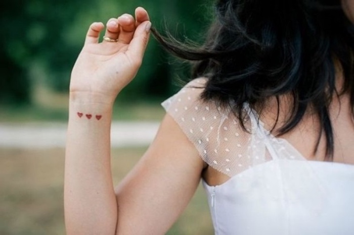 petit tatouage poignet femme, motif coeur, trois coeurs rouges, robe de mariage