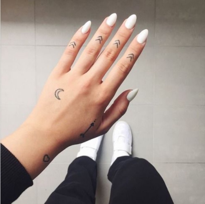 petit tatouage femme, des flèches sur les phalanges des doigts, croissant de lune, flèche et coeur, main poignet, doigt