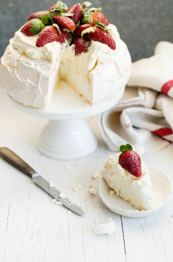 un gâteau pavlova aux fraises nappé de crème fouettée, dessert australien à base de meringue