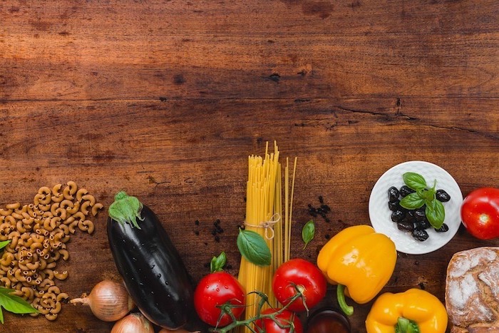 plat équilibré, légumes, poivrons, spaghetties, table en bois, recettes rapides et équilibrées, oignon, olives
