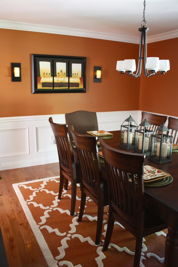 une salle à manger élégant couleur terracotta rehaussée par un soubassement en bois blanc