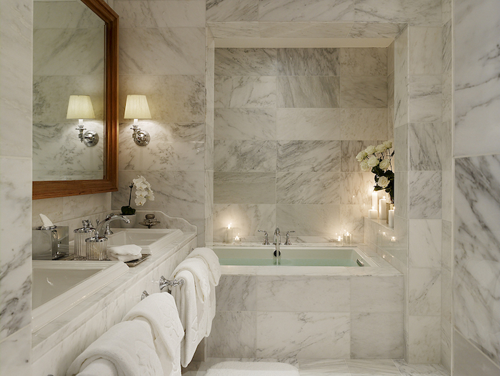 deco salle de bain, serviettes blanches, dallage marbre, cadre miroir en bois, baignoire, bougies