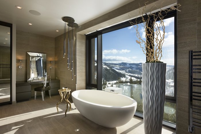 decoration salle de bain, carrelage beige, éclairage LED, porte-serviette métallique, petite table ronde en or