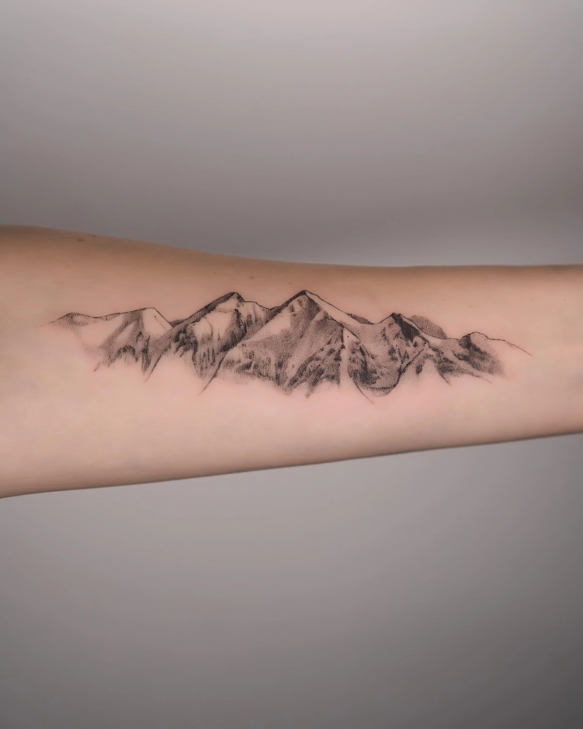 signification tatouage de montagne sur bras paysage realiste