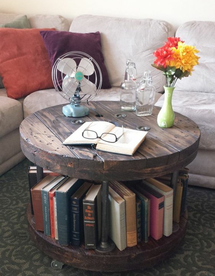 touret deco, table basse avec une bibliothèque, espace de rangement pour livres, plateau en bois, livre, bouquet de fleurs, canapé gris et coussins multicolores