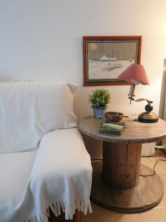 canapé blanc, touret deco table de service, lampe vintage, plante, deco murale photo en noir et blanc, carrelage marron
