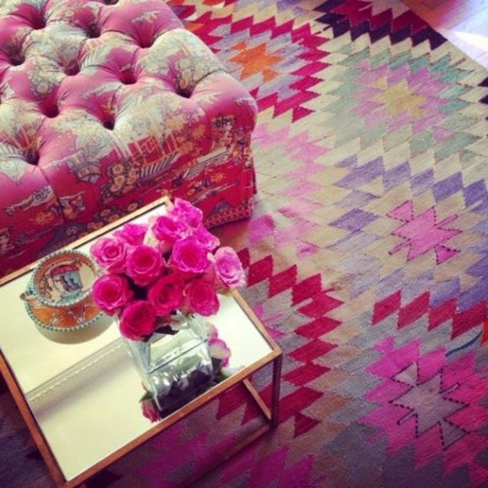 tapis ethnique, imprimés multicolores en rose et lilas, grand pouf rose