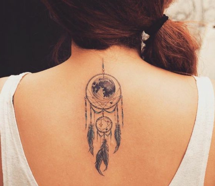 tatouage attrape reve sur la nuque, deux cerceaux de tailles diverses, globe terrestre, plumes encre noir, femme aux cheveux roux