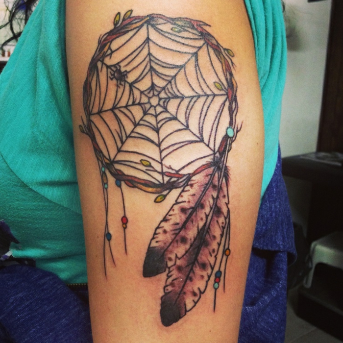 attrape reve tatouage bras, filet toile d'araignée et cerceau en branches d arbre, des plumes en noir et marron, petites perles décoratives